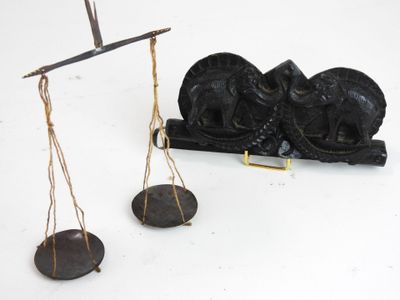 une balance sur laquelle se trouvent une statue et une paire de plateaux