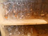 many empty wine glasses on a shelf in the kitchen