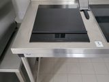 a stove top on a stainless steel table in a kitchen