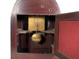 a small wooden clock with a bell inside of it