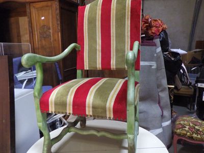 une chaise à rayures rouges et vertes posée sur une table blanche