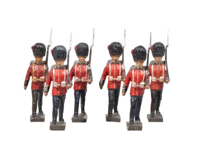 three figurines of soldiers in red uniforms holding rifles