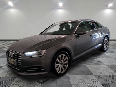 a gray audi parked on a checkered tile floor in a garage