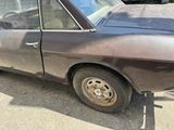 an old car that has been rusted out in the parking lot