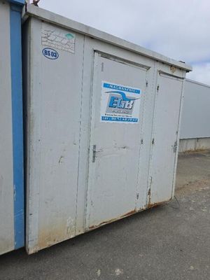 des toilettes portables blanches installées au milieu d'un parking