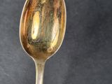 a close up of a spoon on a table with a black background