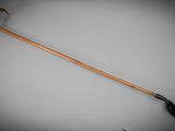 an old wooden walking stick with a black handle on a gray background