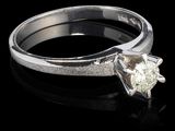 une image d'une bague en diamant sur une surface noire