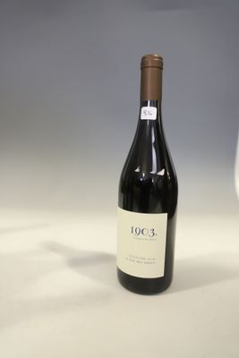 a bottle of wine sitting next to a glass of wine
