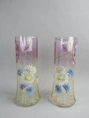 deux vases avec des fleurs peintes dessus, posés sur une table