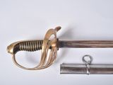 une épée avec une poignée en métal et une paire de ciseaux à côté