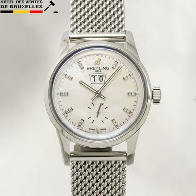 un gros plan d'une montre argentée au cadran blanc