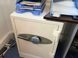 une pile de dossiers posée sur un bureau, à côté d'un classeur