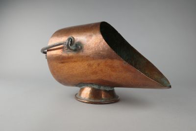 un petit objet en cuivre en forme d'oiseau posé sur un socle