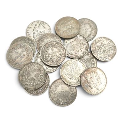 une pile de vieilles pièces d'argent sur une surface blanche