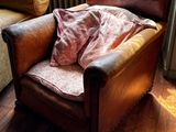 une chaise marron recouverte d'une couverture, placée devant un radiateur