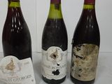 three bottles of wine sitting on a table next to a piece of paper