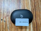 des AirPods noirs posés sur une table en bois