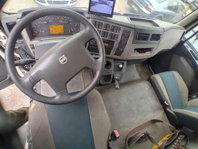 steering wheel and dashboard of a truck with a laptop on the dashboard