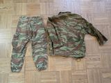 a camouflage jacket and pants laying on the floor