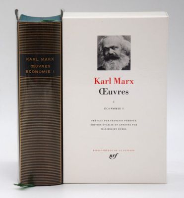 the book is sitting next to a book with a picture of karl marx on it