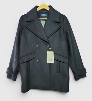 un gros plan d'un manteau suspendu à un cintre accroché au mur