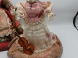 deux figurines représentant une femme et un homme avec un violon