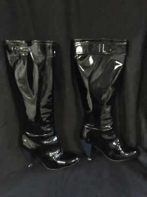 une paire de bottes noires posée sur un tissu noir