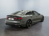 the rear of a grey audi s5 sedan parked in a showroom