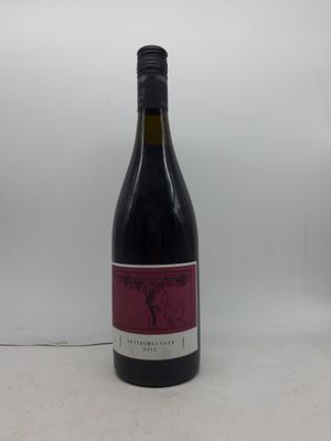 la bouteille de vin rouge est posée sur une surface blanche
