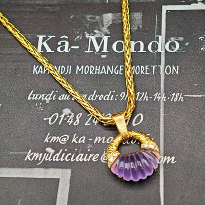 une chaîne en or avec un pendentif en forme de fleur violette