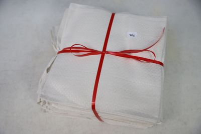a stack of four white napkins tied with a red ribbon