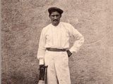 une vieille photo d'un homme en costume blanc et chapeau