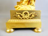 une statue en or représentant une femme assise sur un banc