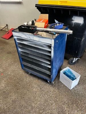 une photo d'un garage avec des outils par terre