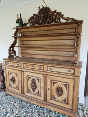 a wooden cabinet with carvings on it in a room