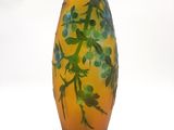 un vase jaune orné de feuilles vertes sur fond blanc