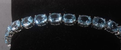 un gros plan d'un bracelet orné de pierres bleues, présenté dans une vitrine