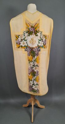 une croix jaune et blanche ornée de fleurs violettes, posée sur un mannequin