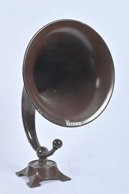 un gramophone à l'ancienne posé sur un support, sur fond blanc