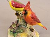 a figurine of two birds sitting on a tree branch