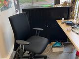 a desk with a computer and a chair in a room
