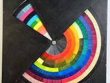 a black piece of paper with a colorful circle on it