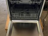 an open dishwasher sitting on top of a wooden table