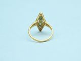 a close up of a gold ring with a green stone in it