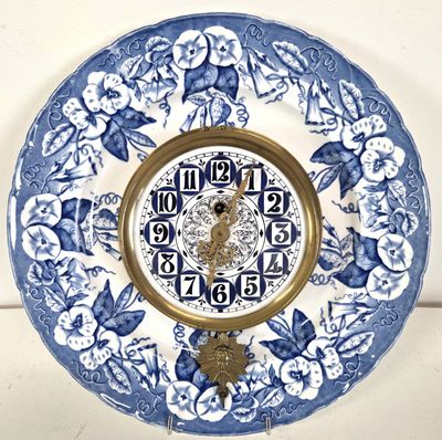 a blue and white plate with a clock on it