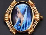un gros plan sur la photo d'une femme en robe bleue portant une broche dorée