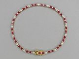 un gros plan sur un collier rouge et blanc muni d'un fermoir doré