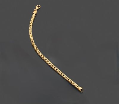 un bracelet à chaîne en or avec un fermoir sur fond noir