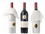 three bottles of wine are wrapped in plastic bags on a white surface